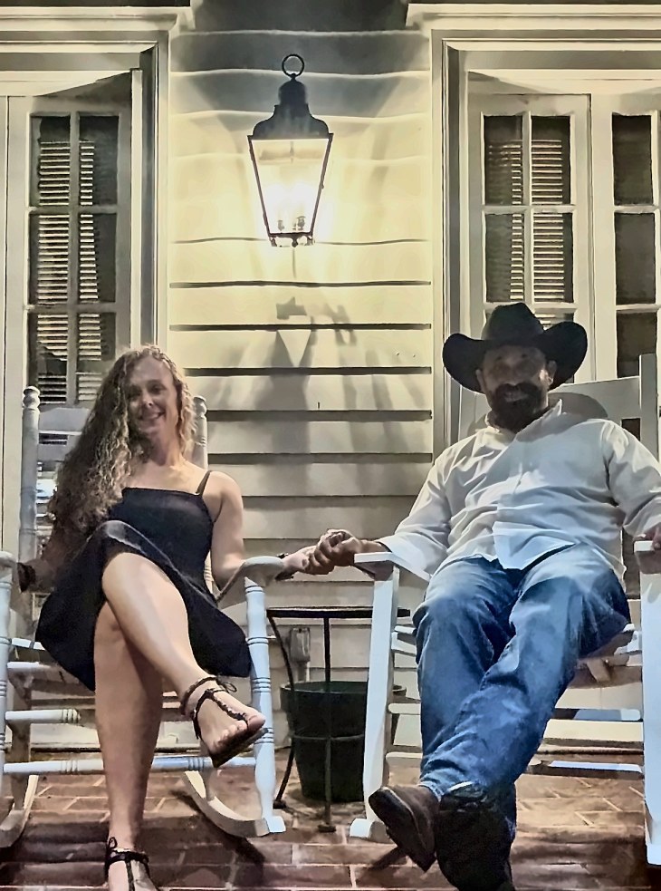 Chad and his wife relaxing in rocking chairs on a front porch